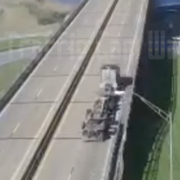 Semi truck’s container chassis breaks in half and smashes into highway divider